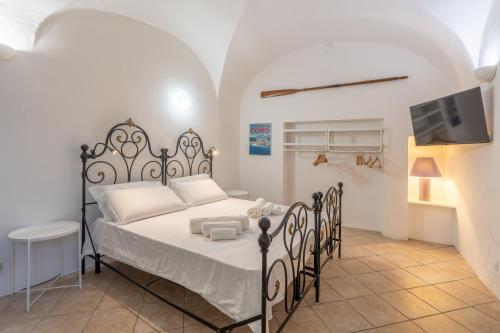 a bedroom with a bed and a tv in a room at Historic Borgo Lake Como Campidoglio 3 in Lenno
