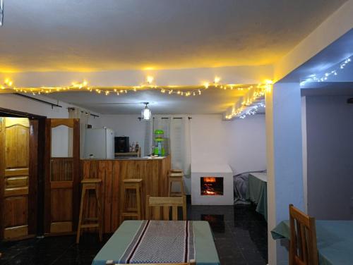 a room with a table and a kitchen with lights on the ceiling at Chez Rasoa Andasibe in Moramanga