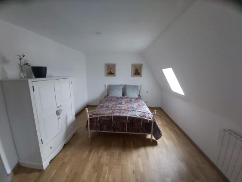 a small bedroom with a bed and a dresser at Manoir Saint-Eloi in Noyon