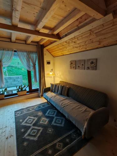 a living room with a couch and a large window at Casa Lucia in Dămuc
