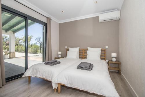 two beds in a bedroom with a large window at Villa Isabelle by Algarve Holidays - Loule in Loulé