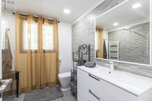 a bathroom with a sink and a toilet and a mirror at Villa Isabelle by Algarve Holidays - Loule in Loulé