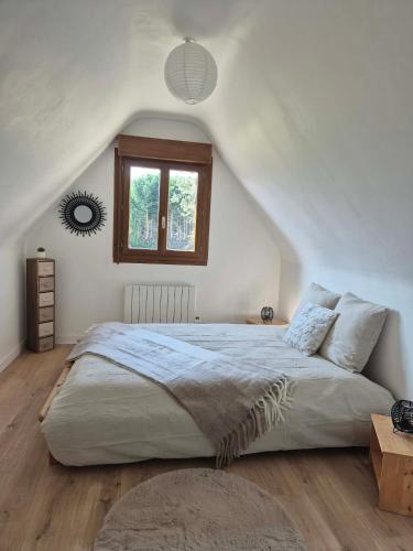 a bedroom with a large bed and a window at Maison proche dinan au calme in Aucaleuc