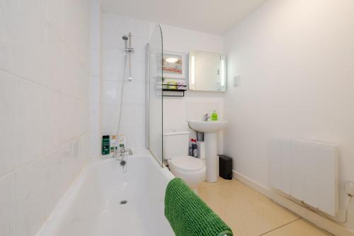 a bathroom with a tub and a toilet and a sink at Group-Friendly Flat - 3 Beds, a Sofa Bed & Parking in Andover