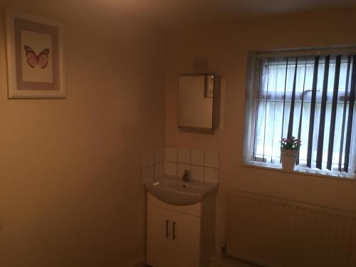 a bathroom with a sink and a window at 24/7 London Hostel in London