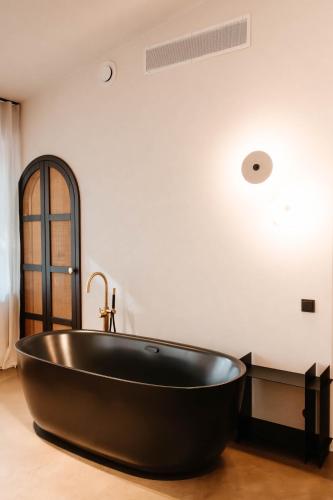 eine schwarze Badewanne in einem Badezimmer mit weißer Wand in der Unterkunft Bagatelka Cenrum Rekreacyjno-Hotelowe in Miłosław