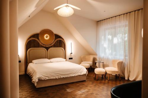 ein Schlafzimmer mit einem Bett mit großem Kopfteil und Stühlen in der Unterkunft Bagatelka Cenrum Rekreacyjno-Hotelowe in Miłosław