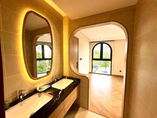 a bathroom with a sink and two mirrors at The Sol Hotel in Phú Quốc