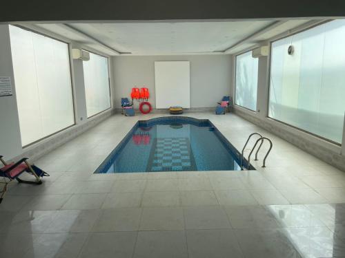 an indoor swimming pool in a large room with windows at استراحة العمران in Murayjāt