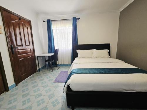 a bedroom with a large bed and a window at Larami House Narok in Narok