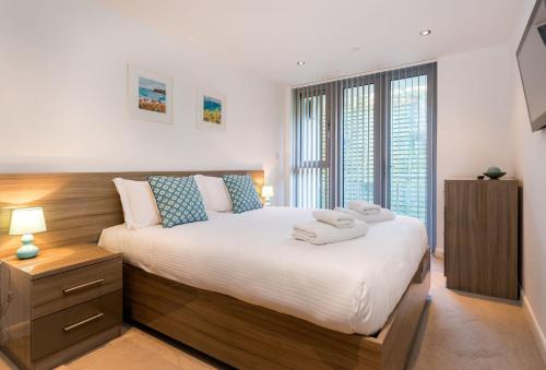 a bedroom with a large bed with towels on it at 11 Zinc in Newquay in Newquay