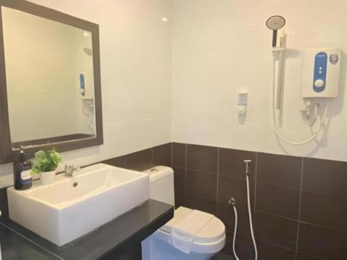 a bathroom with a sink and a toilet and a mirror at Get Inn Hotel at 1 Capital Holdings in Gua Sai