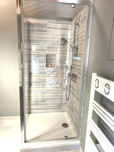 a shower with a glass door in a bathroom at Chambre indépendante, sdb privée in Saulcet
