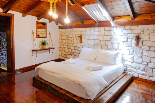 a bedroom with a large bed in a stone wall at Anhel Hotel in Berat