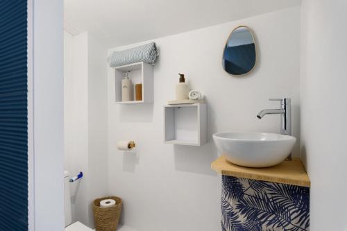 a white bathroom with a sink and a mirror at Fenêtre sur le Neron in Quaix