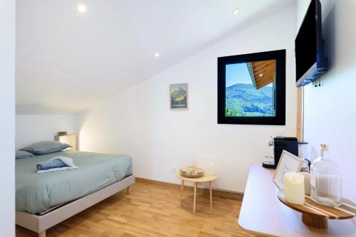 a bedroom with a bed and a desk and a window at Fenêtre sur le Neron in Quaix