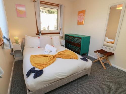 a bedroom with a large bed with an orange blanket at Crown Cottage in Dunfermline