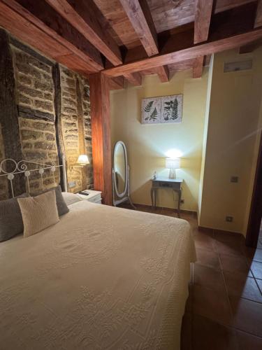 a bedroom with a bed and a table with a mirror at APARTAMENTOS La Colmena APT - 1 - AT-CC-00248 in Gata