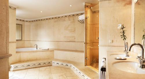 a bathroom with a tub and a sink at Puente Romano Marbella in Marbella