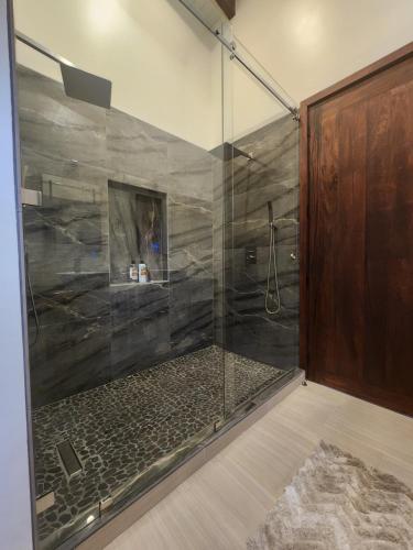 a bathroom with a shower with a glass shower stall at Sunset Oasis Waterfront in Maya Beach