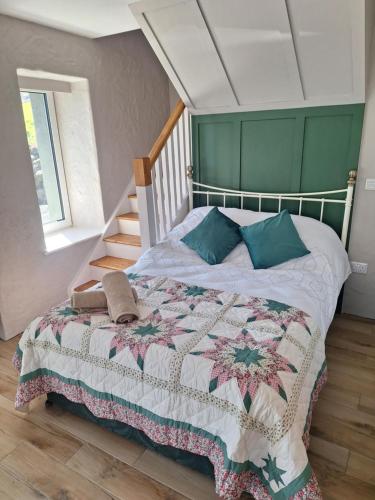 a bedroom with a bed with a quilt on it at Sunny Hills Cottage in Cornamona