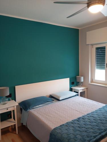 a bedroom with a bed and a blue wall at Punta sul Garda in Torri del Benaco