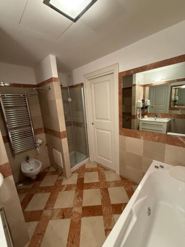 a bathroom with a tub and a shower and a toilet at Albergo Centrale in San Ginesio