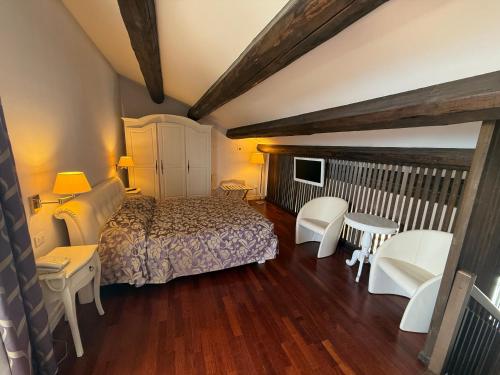 a bedroom with a bed and chairs and a television at Albergo Centrale in San Ginesio
