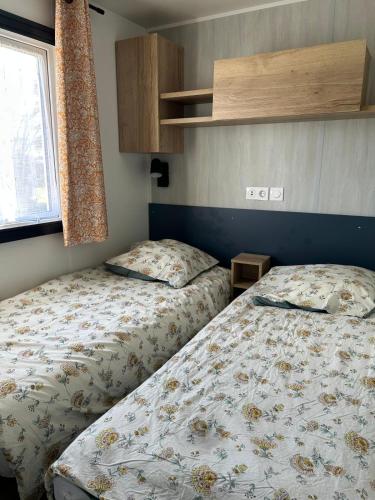 a bedroom with two beds and a window at domaine de litteau in Litteau