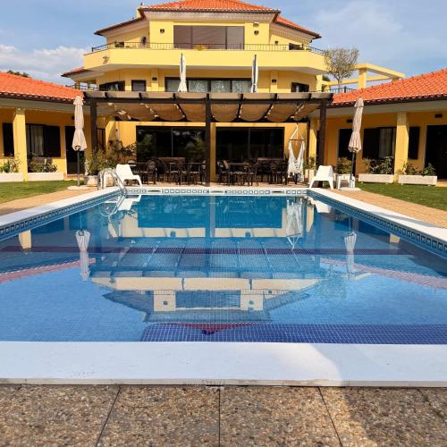 a swimming pool in front of a house at Quinta Dos Amarelos Sesimbra in Sesimbra