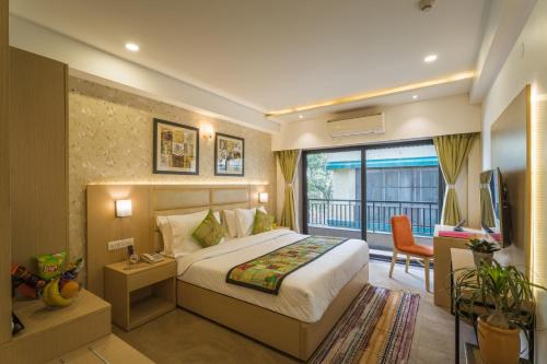 a hotel room with a bed and a balcony at Tripli Hotels Shourya Residency in Udaipur