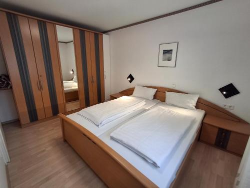 a bedroom with a large bed with white sheets at Appartementhaus Bayern Residenz in Bad Füssing