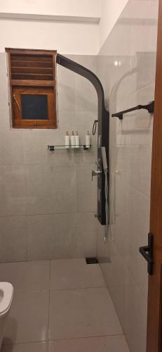 a bathroom with a shower with a sink and a toilet at Royal Horizon in Nuwara Eliya