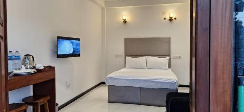a hotel room with a bed and a television at Royal Horizon in Nuwara Eliya