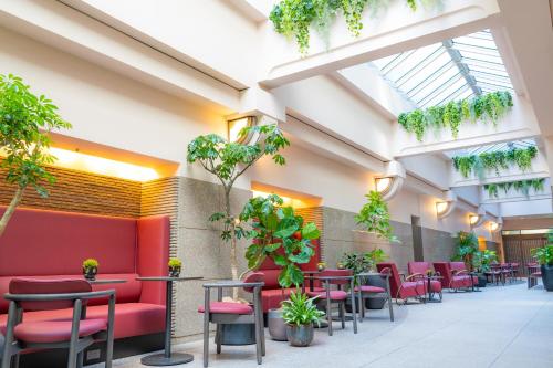 a waiting room with red chairs and plants at Koraku Garden Hotel Tokyo in Tokyo