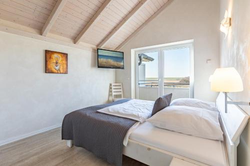 a bedroom with a bed and a window at Ferienhaus Nordspitze in Dagebüll