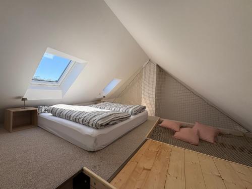 a attic bedroom with a bed and a window at Apartmán Ve Štítu in Lomnice nad Popelkou