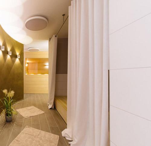 a bathroom with a shower with a white curtain at SunCliff Lodge - exklusive private Sauna, Sanarium, Kamin und Meerblick in Dranske