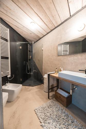a bathroom with a tub and a sink and a shower at ROSTAGNI 1834 apt with pool in the Barolo region in Novello