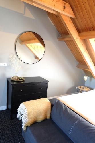 a bedroom with a bed and a mirror at Zuidzuidwest in Zierikzee
