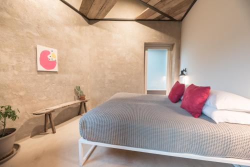 a bedroom with a large bed with red pillows at ROSTAGNI 1834 apt with pool in the Barolo region in Novello
