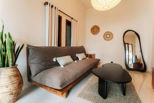 a couch in a living room with a table and a mirror at Villa Allegra in Mantaak