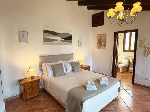 a bedroom with a large bed and a bathroom at Sa Màniga in Fornalutx