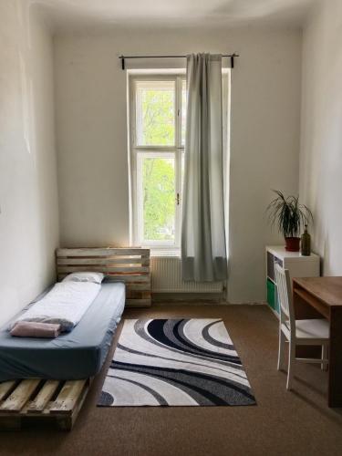 a bedroom with a bed and a window and a table at Green Park Rooms Brno in Brno