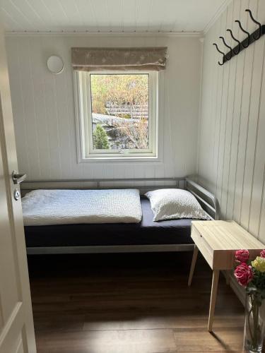 a bed in a room with a window at Fjordhytte-13 in Ænes