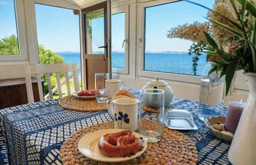a table with a blue and white table cloth with food at Hedwigsblick - Sommerhäuschen mit Weitblick & Privattreppe zum Strand in Westerholz