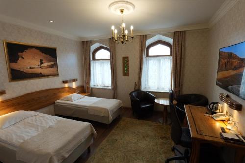 a hotel room with two beds and a desk at Georgi Hotell in Võru
