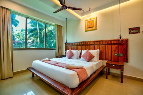 a bedroom with a large bed and a window at Bliss By Stays,Calangute in Calangute