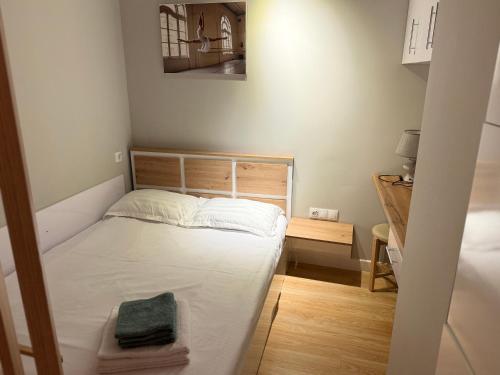 a small bedroom with a bed and a table at A & A GLOBAL PROPERTY RENTALs in Yerevan