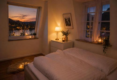 a bedroom with a bed and a window with lights at Villa Ardoise direkt an der Mosel zwischen Cochem und Koblenz in Brodenbach